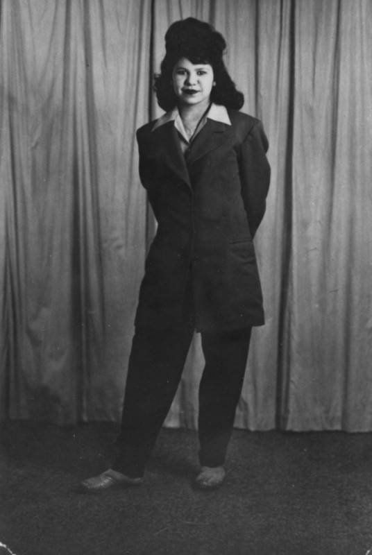 1944 black and white photograph of Ramona Fonseca, a young Mexican-American woman, posing confidently in a stylish zoot suit, representing the fashion and women of that era. The image is part of the historic Shades of L.A. Collection, highlighting the diverse families and communities in Los Angeles.