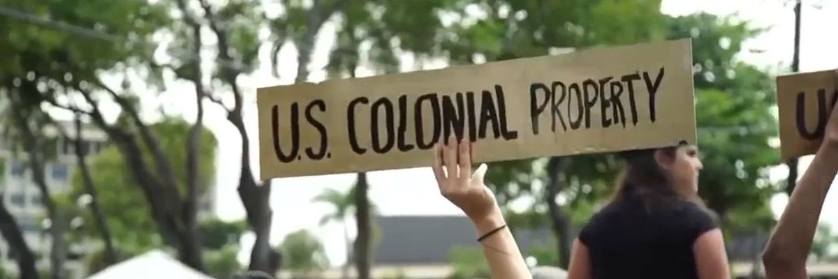 cardboard sign at a protest in puerto rico that reads "u.s. colonial property" 