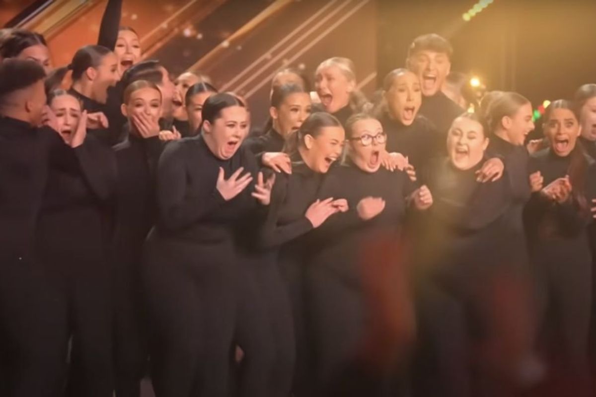 Dancers dressed all in black celebrating on stage