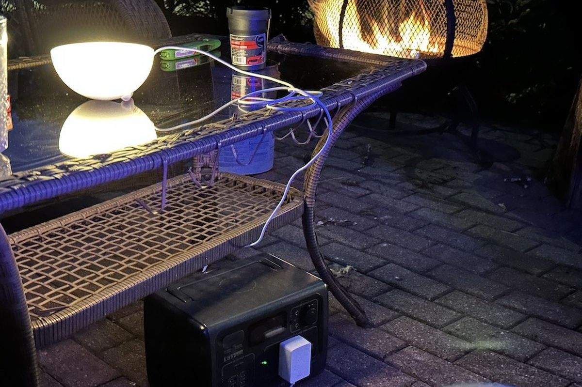 a photo of BLUETTI EB55  Portable Power Station outside powering a smart light