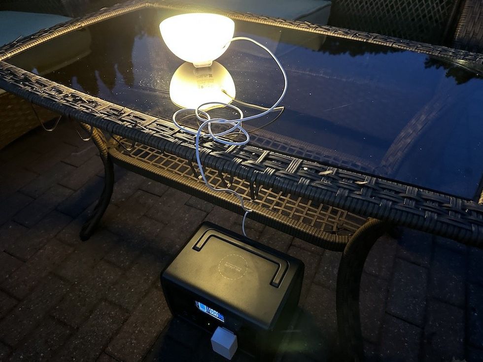 a photo of BLUETTI EB55 Portable Power Station powering an outdoor light