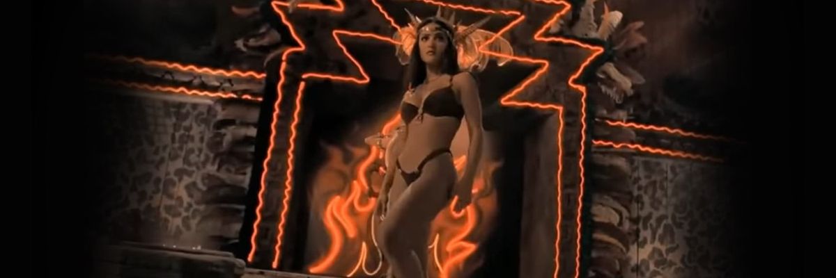 movie still from the film "From Dusk Til Dawn" starring Salma Hayek, showing Salma in a bikini with flames in the background
