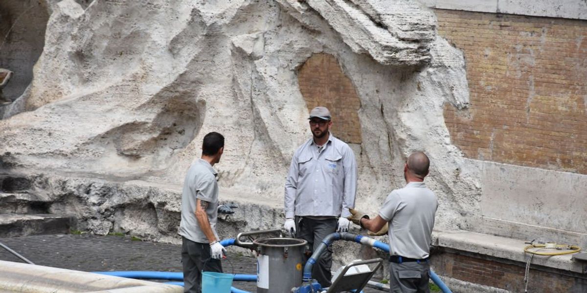 NextImg:Climate vandals dye water in Rome's Trevi Fountain black; police drag them away