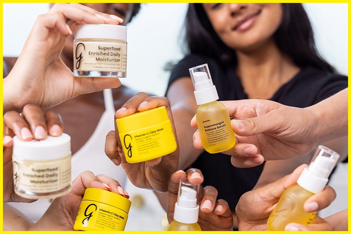 Hands holding various skincare products with jars and bottles.