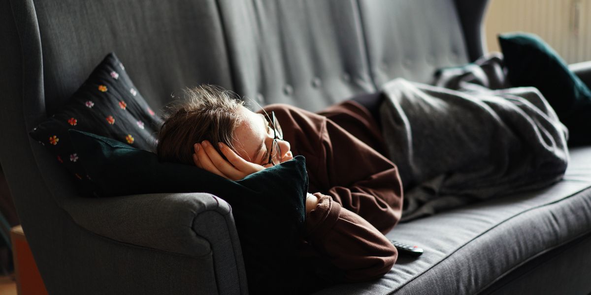 woman lying on gray couch