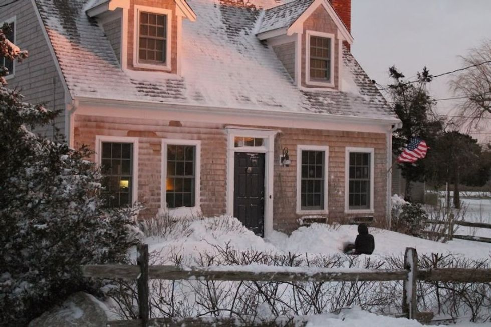 cape cod house in the snow