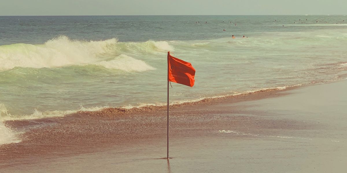 Red flag planted on a beach