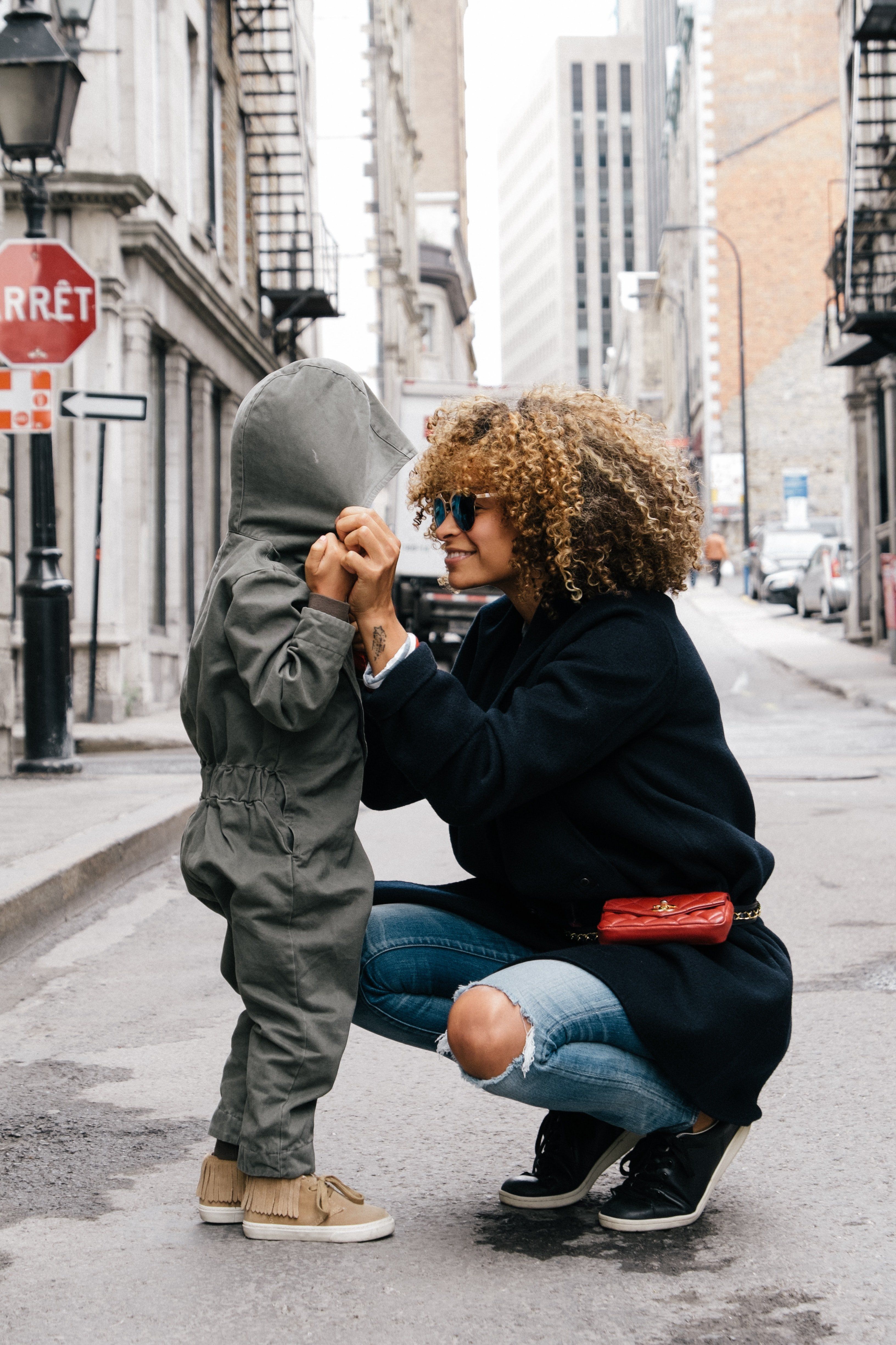 woman holding kid in the street