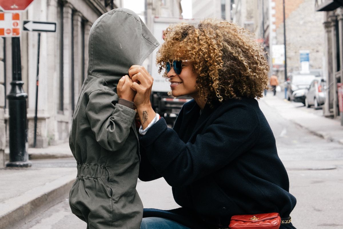 woman holding kid in the street