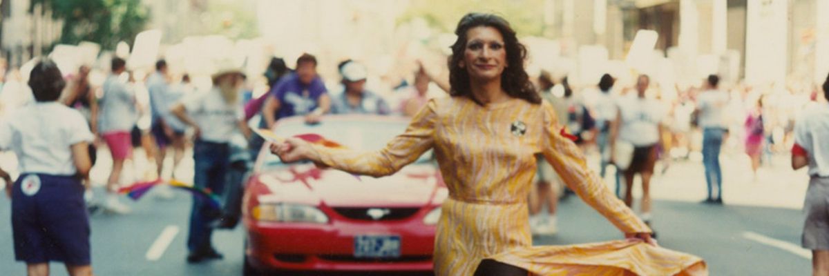 A photograph of Sylvia Rivera in a yellow dress during a march