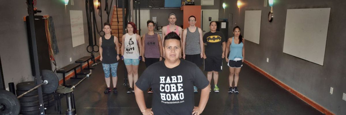 Coach Nathalie Huerta in a gym with seven people behind her inside a gym