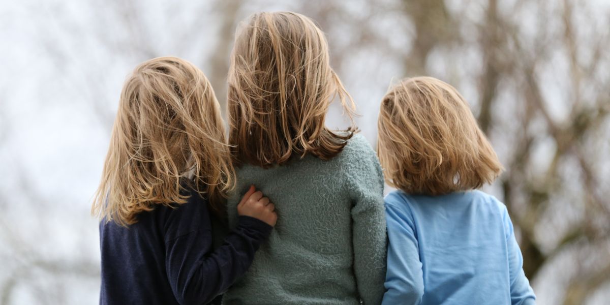 three blond haired siblings photographed from behind