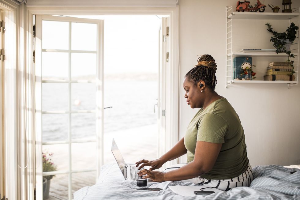 Black-businesswoman-working-from-home-on-laptop-in-bed