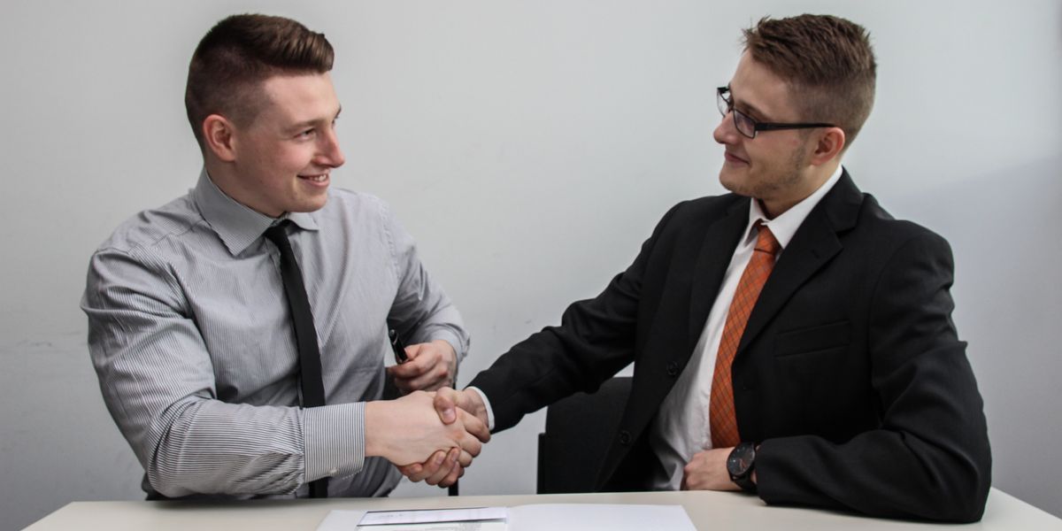 Two men shaking hands during job interview