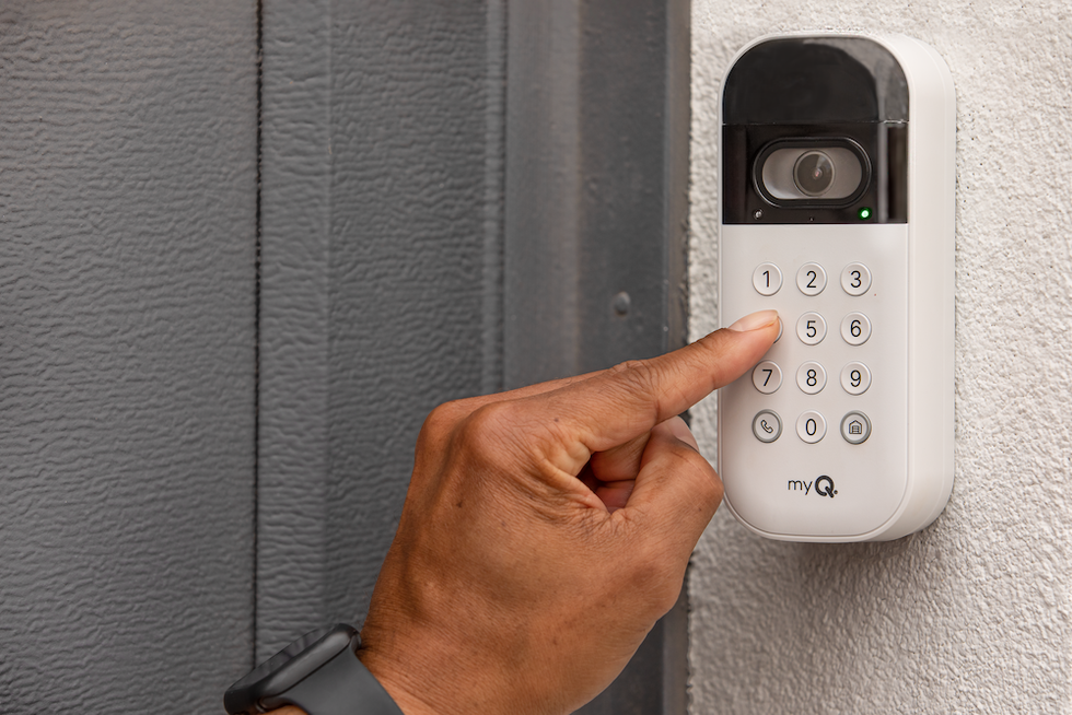 a photo of a person pushing the keypad on myQ Smart Garage Video Keypad