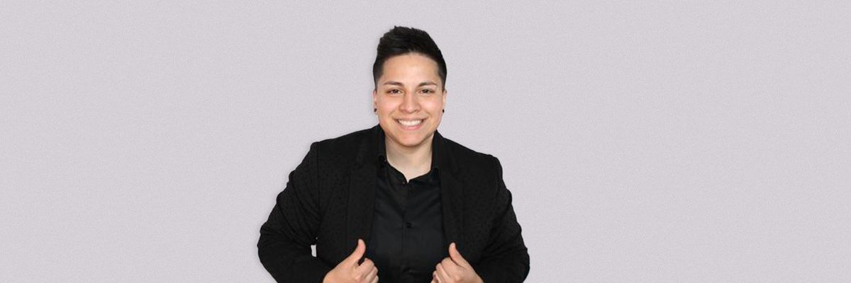 a photo of DJ KICKIT in a black blazer and top with a simple white background