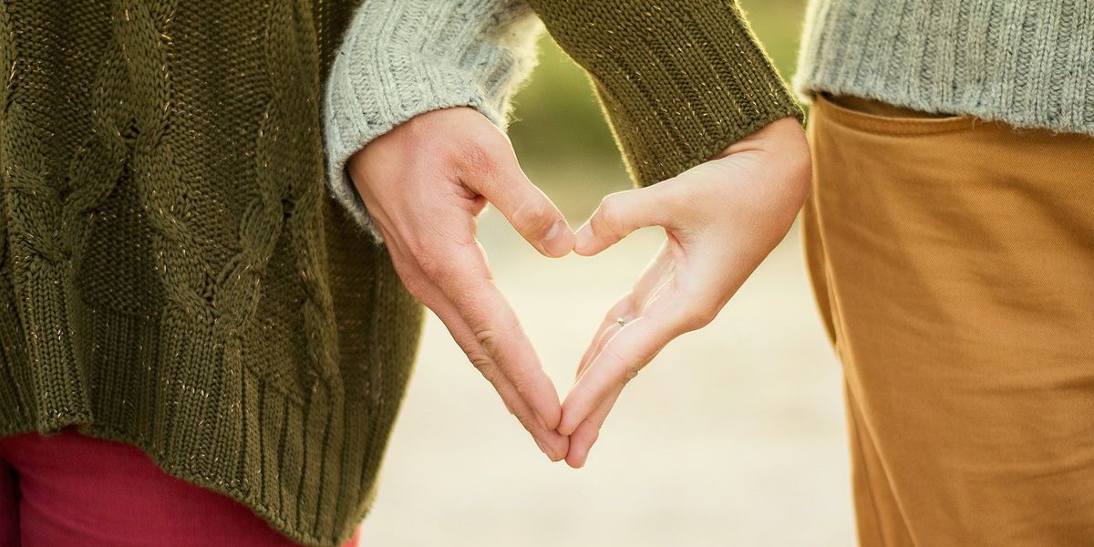 Couple forming heart shape with hands