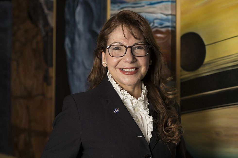 Photo of Adriana Ocampo in a suit wearing a NASA pin