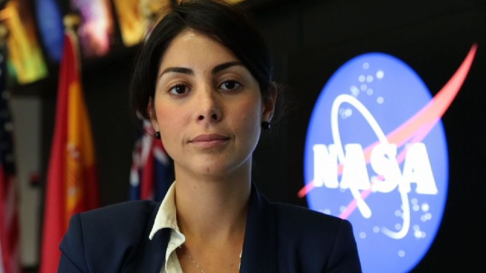 Photo of Diana Trujillo standing in front of the NASA logo