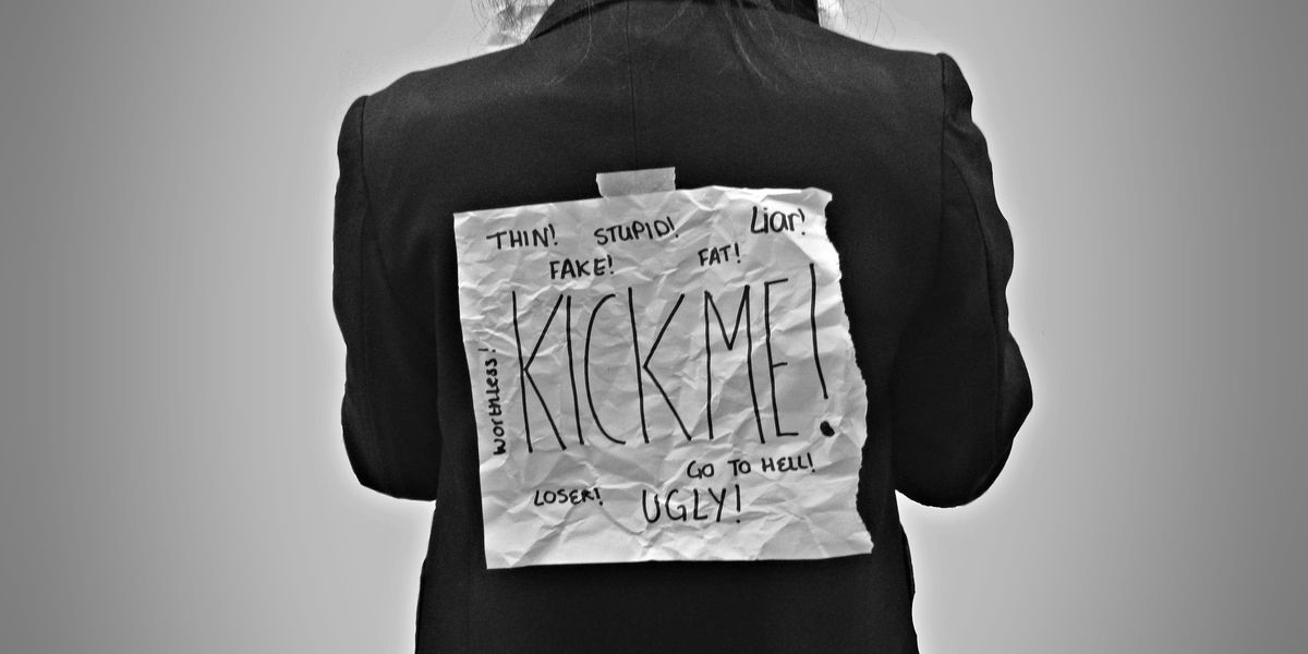 Person with "Kick Me" sign secretly taped to their back