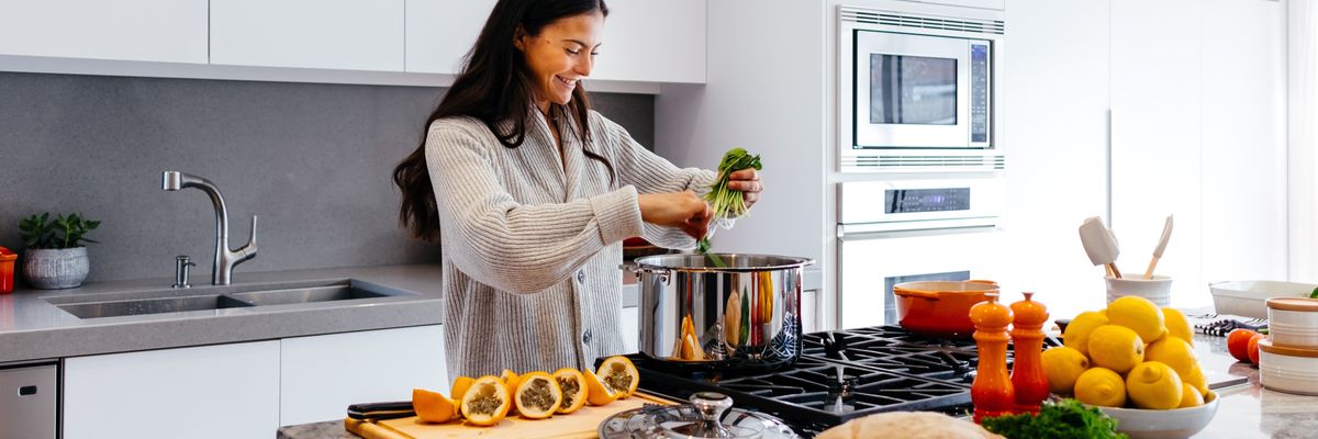 woman smiling while cooking