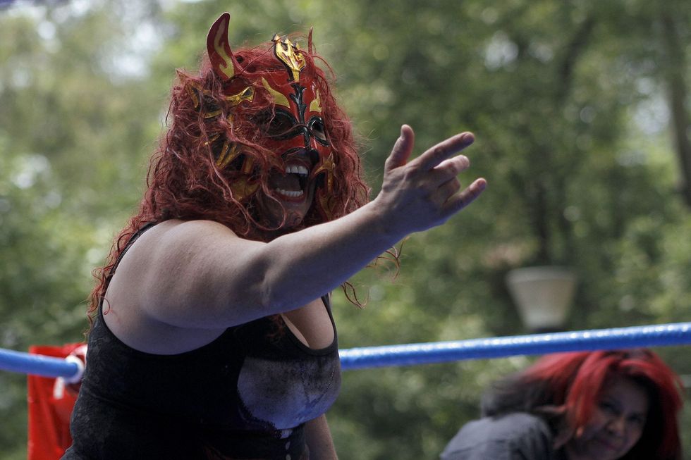 a photo of a female lucha libre wrestler in a mask shouting