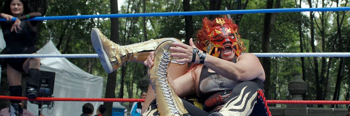 a photo of a female lucha libre wrestler holding another woman in a lock
