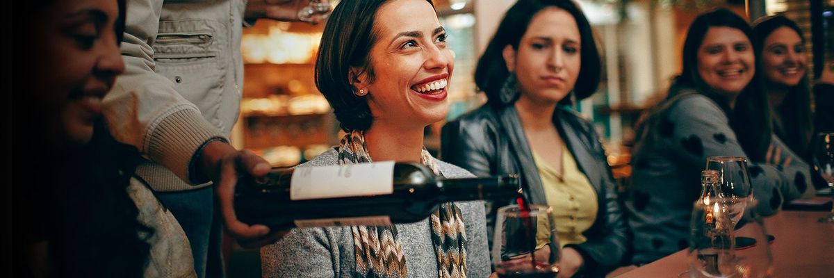 a woman being served wine at a vineyard