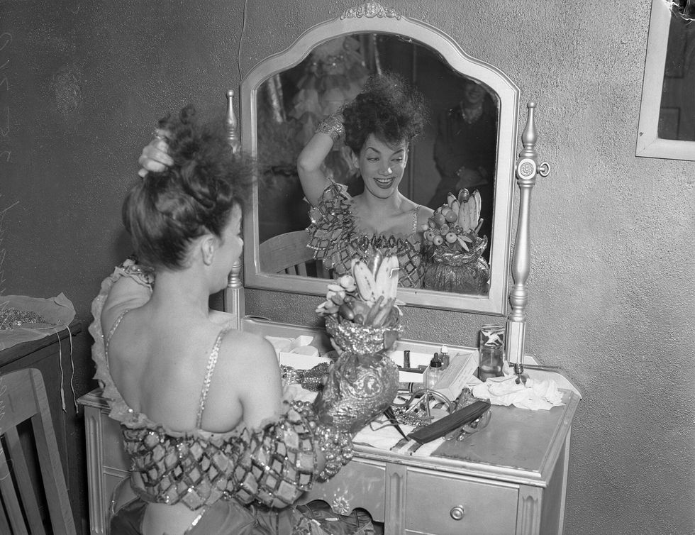 Actress Carmen Miranda at dressing table with her fruit hat, Los Angeles, California, circa 1941