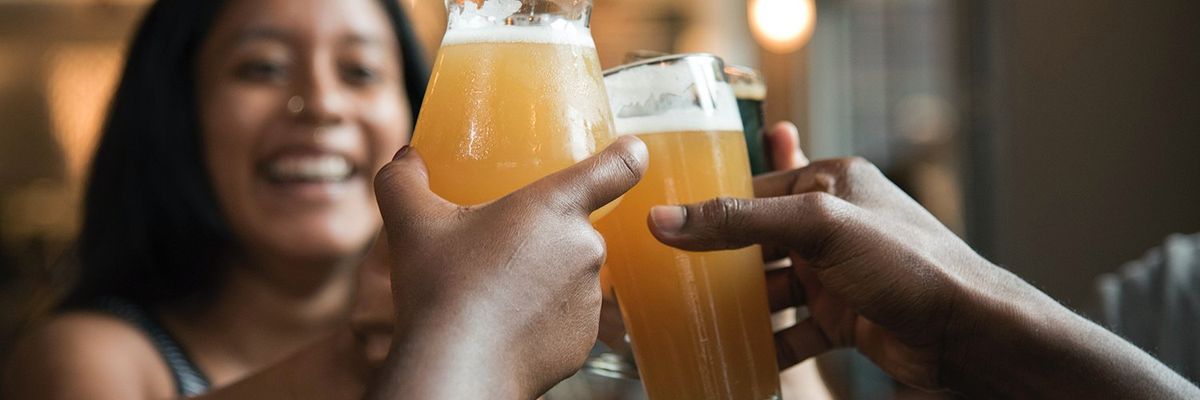 a group of friends cheering with beer glasses