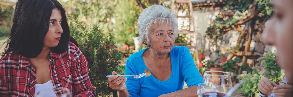 an image of young woman and an old woman eating at the table