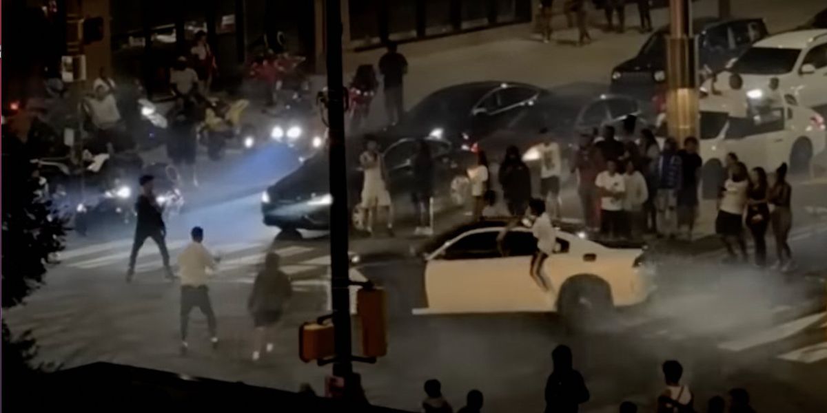 Mob of 500 takes over intersection, gawks at cars doing donuts at 2 a.m. After cops move in, officer is hit by vehicle — and driver flees scene.