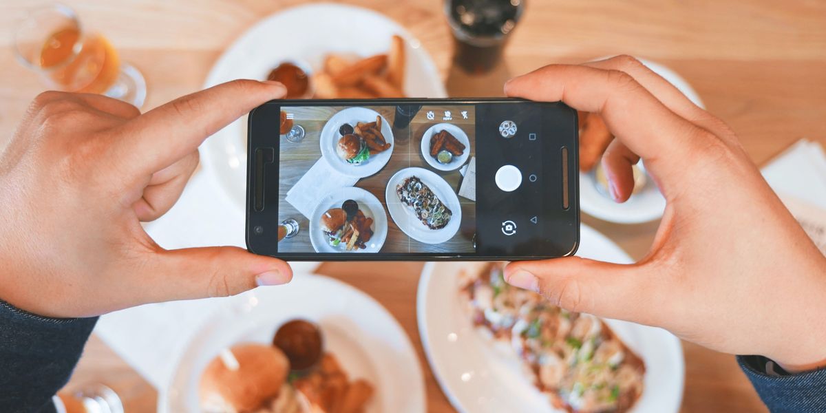 Person taking a picture of their food with their phone.