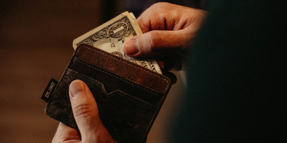 A man pulls dollar bills out of his wallet