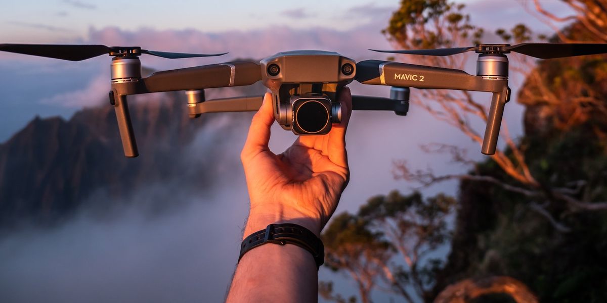 A hand holds a camera/flying drone