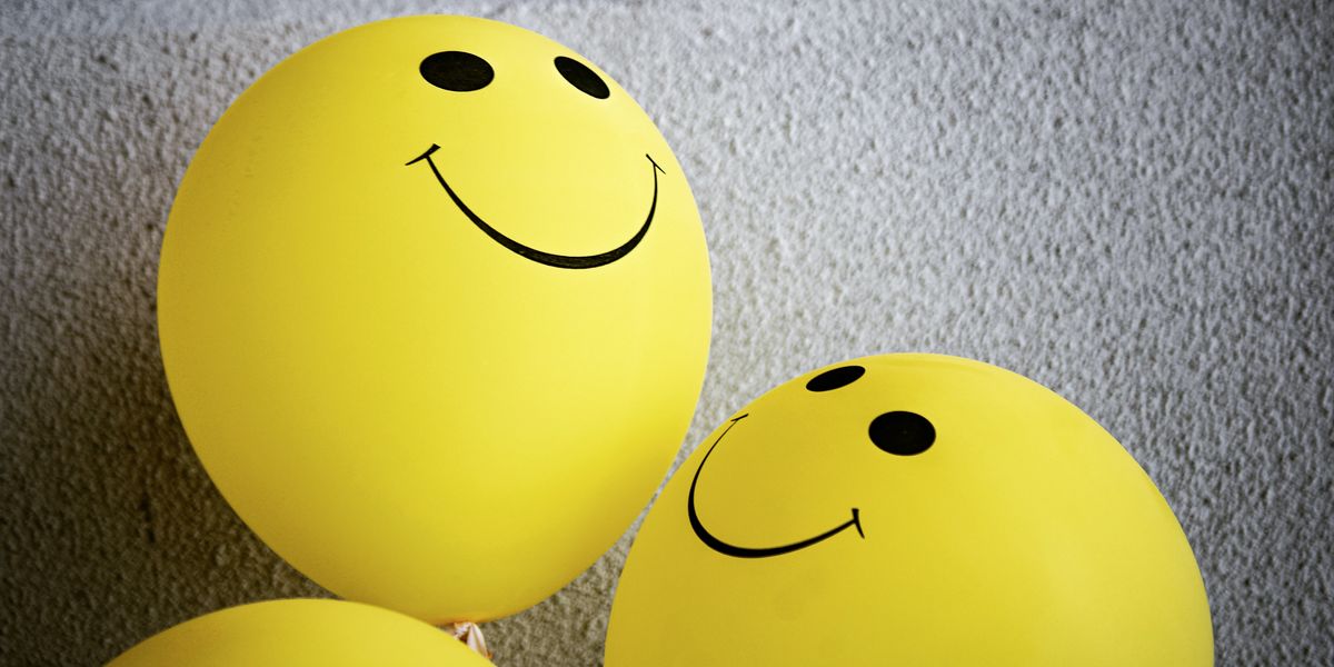 yellow smiley balloon on gray textile