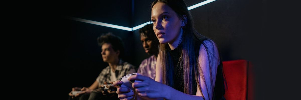 an image of a girl playing videogames with two guys