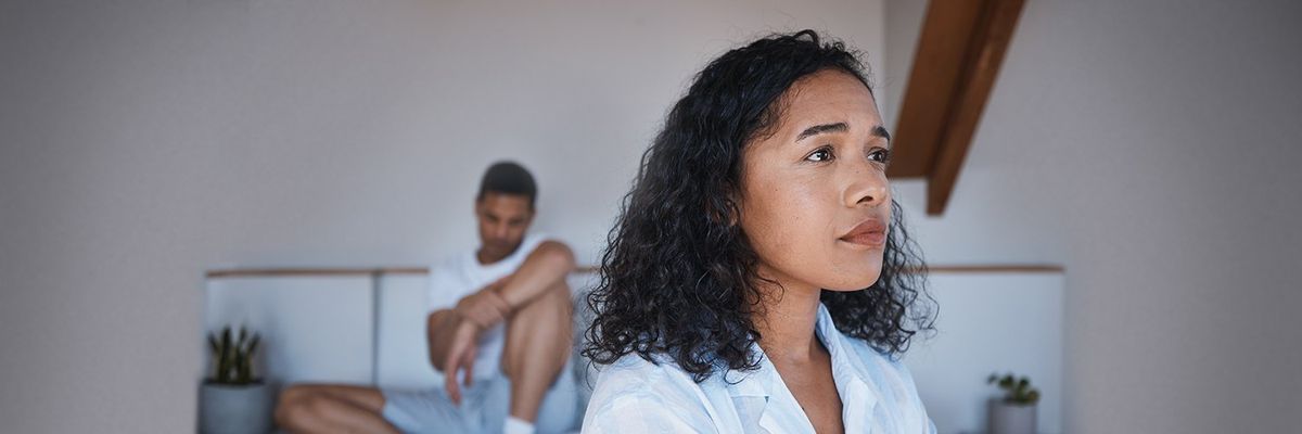 an image of a woman looking elsewhere while a man is sitting behind her