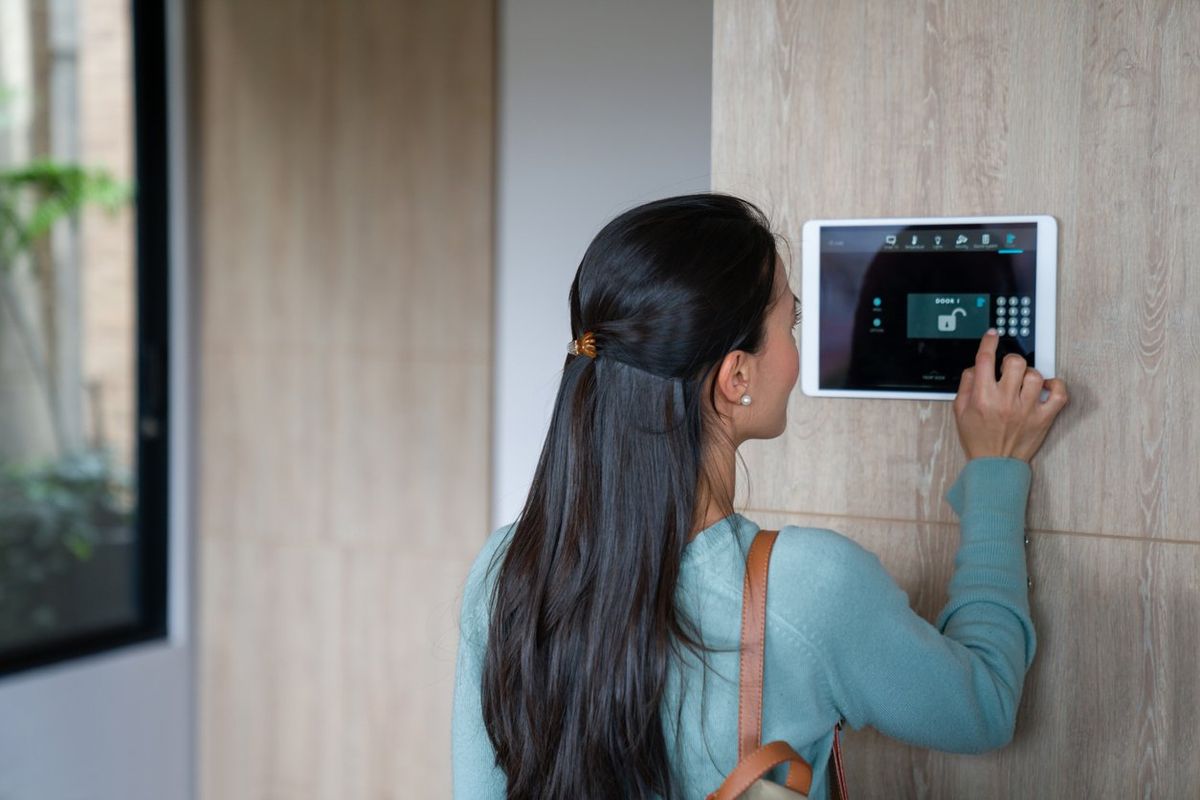 a woman entering a PIN to her smart home system