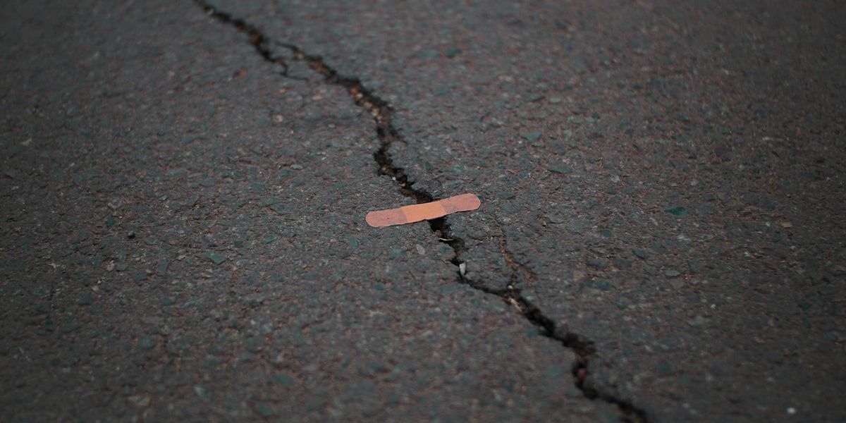 A bandaid is set over a crack in the street