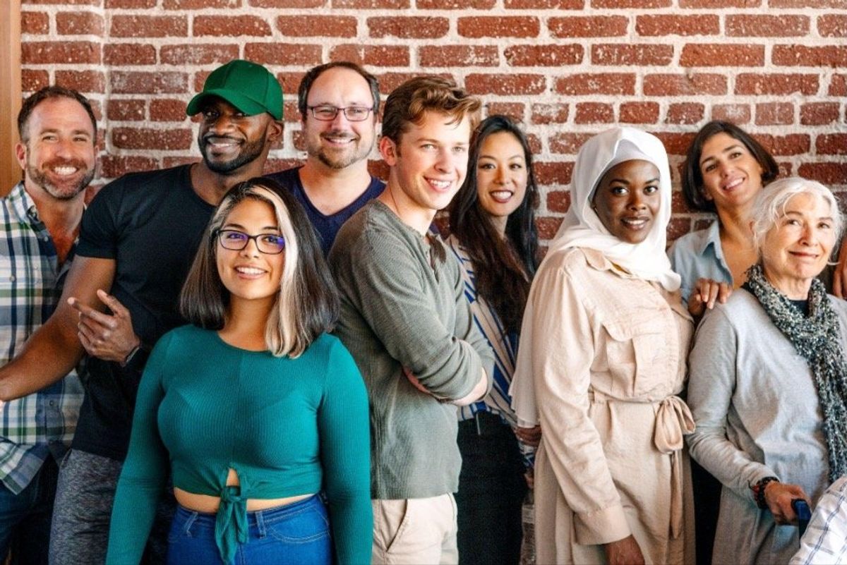 Group of diverse people standing in front of a brick wall