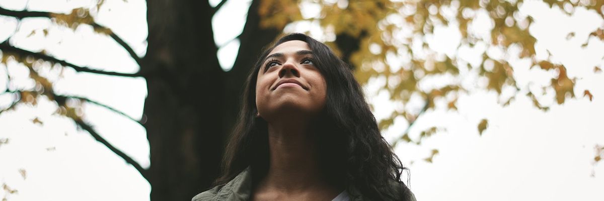 a dark haired woman looking up at the sky