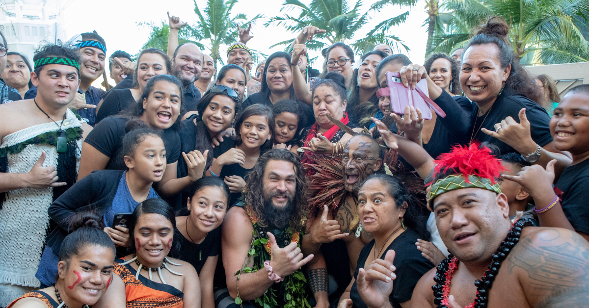 Jason Momoa (center) poses for a photo with fans in Honolulu, Hawaii.
