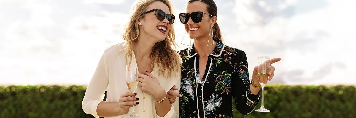 an image depicting two women with champagne glasses laughing