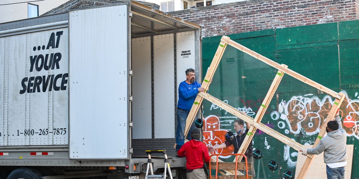 Men moving a window into a moving truck