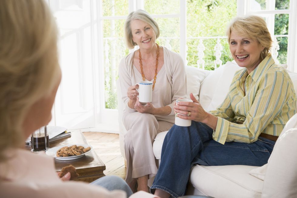 3 women gather in a living room to catch up.