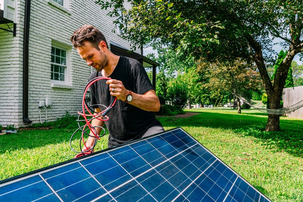 a man unraveling wires for solar panels