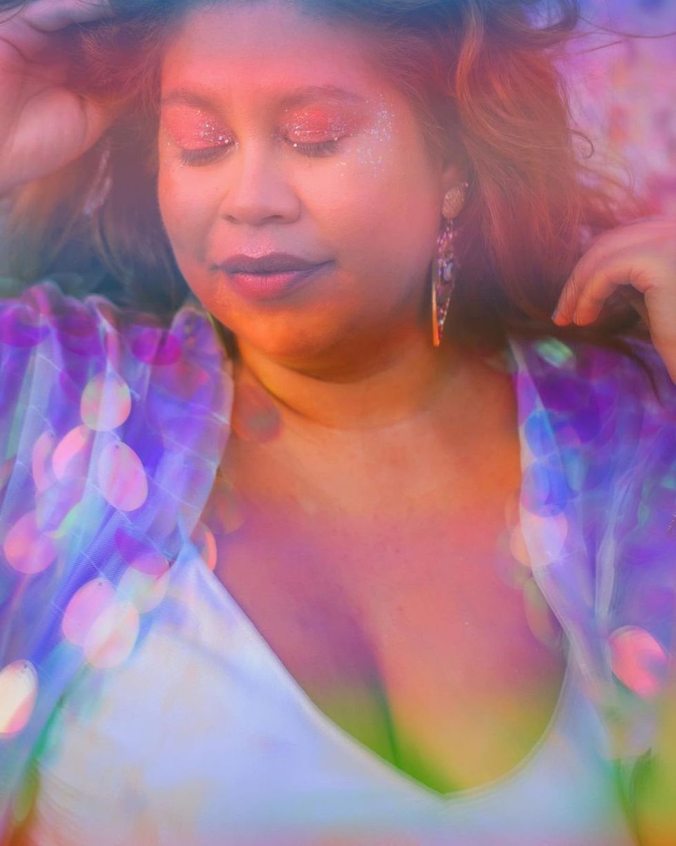 An image of a woman in colorful makeup with a colorful filter on it