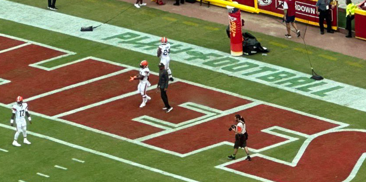 The words 'End Racism' are seen painted in an end zone during an NFL  football game