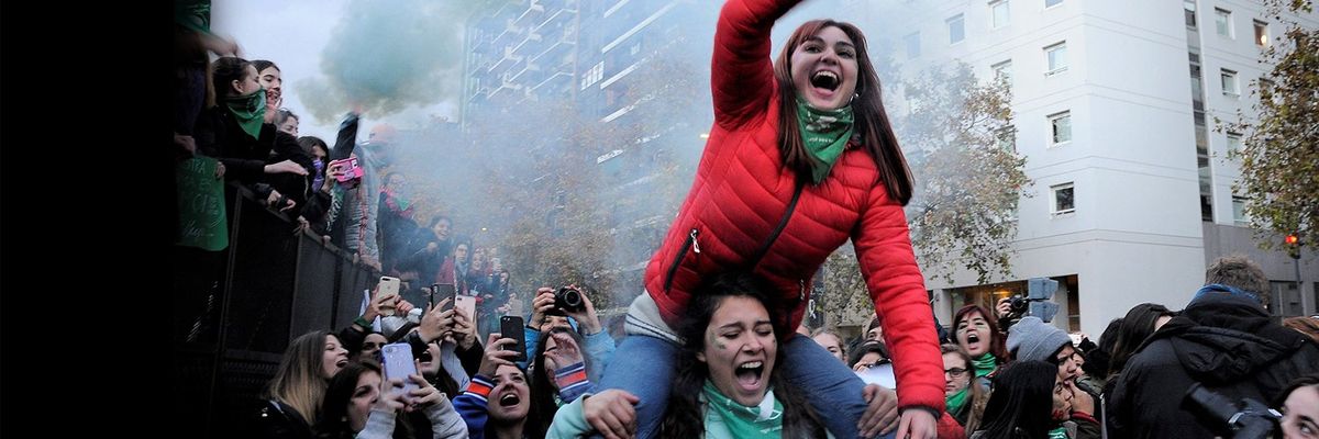 a smiling woman on top of another woman's shoulders at a march for abortion rights in Mexico